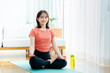 © wheeljack - リビングでヨガをする若い女性