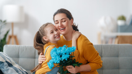 Wall Mural - daughter is congratulating mom and giving her flowers