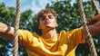 © Chotijah - Young Man Relaxed on Rope Swing Outdoors
