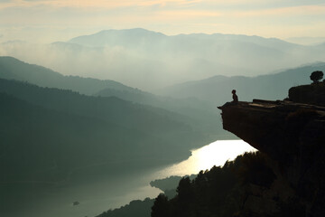 woman sitting and contemplating nature in a cliff