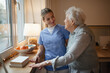 © Halfpoint - Caring healthcare worker visiting a senior patient at home.