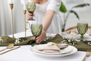 Poster - Young woman setting table for dinner at home, closeup