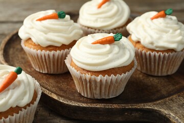 Wall Mural - Delicious carrot cupcakes on wooden table, closeup