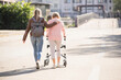 © Westend61 - Granddaughter assisting her grandmother walking with wheeled walker
