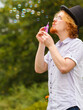 © Voyagerix - Man blowing soap bubbles, having fun