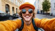 © iuricazac - A young man in a yellow jacket and orange hat taking a selfie with sunglasses while riding a bike on a street.