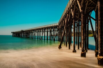 Wall Mural - Serene coastal pier stretches over turquoise waters near Monterey, California.