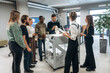 © standret - Gathering, looking at printed product. People are in the office by the 3d printer