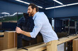 © Valerii Apetroaiei - A man joyfully embraces a TV in an electronics store displaying modern gadgets and design