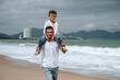 © alexkoral - happy father with child son on the beach by the sea in summer on vacation