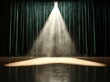 © serdon - The stage is empty, but a green curtain hints at the impending show