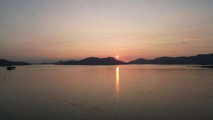 Wall Mural - view of stunning sun reflecting in water while setting behind the cliffs on Okunoshima Island