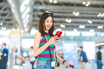 Wall Mural - Tourist passenger beautiful woman using smartphone at international airport terminal for depature with airline transport