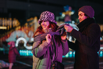 Sticker - Cheerful couple sharing a special moment together against a colorful background of festive lights, showcasing winter atmosphere.