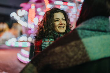 Sticker - A cheerful moment shared between friends outdoors during a lively, colorful winter celebration.