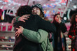 © qunica.com - A joyful moment of friends hugging during a winter evening surrounded by festive decorations.
