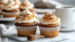 © Phurichai - Delicious caramel topped cupcakes with cream frosting and honey on a white decorative plate