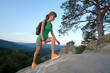 © bilanol - Hiker woman walking on mountain footpath enjoying evening nature. Lonely female traveler traversing wilderness trail. Healthy lifestyle concept