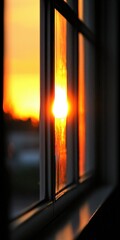 Wall Mural - a vibrant sunset viewed through a window pane. the warm glow of the setting sun casts a beautiful go