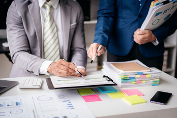 Fototapete - Two men in suits are discussing something on a desk