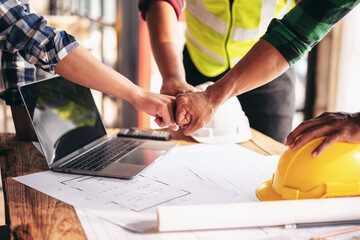 Aufkleber - Three people are shaking hands in front of a laptop and a stack of blueprints