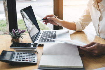 Fototapete - Female accountant calculations and analyzing financial graph data with calculator and laptop Business, Financing, Accounting, Doing finance, Economy, Savings Banking Concept