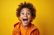 © Vadym - Amazed cute African American child joyfully screams on bright yellow background. Curly hair toddler with open mouth expresses surprise, happiness, fun. Portrait of excited young kid in orange jacket.