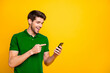 © deagreez - Portrait of his he nice attractive cheerful cheery glad guy wearing violet shirt holding in hands pointing at new gadget web service isolated on bright vivid shine vibrant yellow color background