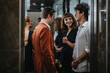© qunica.com - A group of young professionals engaged in casual conversation inside a modern elevator. The setting reflects a contemporary urban lifestyle and social interaction among colleagues.
