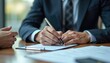 © yuntunen - Insurance broker writing notes during client policy discussion.
