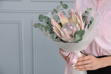 Wall Mural - Woman with beautiful bouquet against light wall, closeup. Space for text