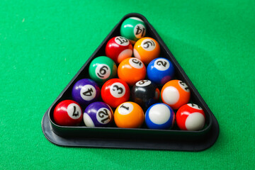 Wall Mural - Billiard balls triangle rack on green table, closeup