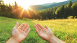 © Bonsales - Hands framing radiant sunrise illuminating verdant mountain valley, symbolizing inner tranquility and spiritual connection