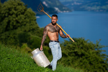 Wall Mural - Sexy man in a village farm. Environmental worker in grassy field. Hardworking farmer in a rural landscape. Country life in summer. Farmer enjoying nature in countryside. Traditional farming.