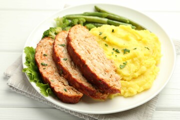 Wall Mural - Delicious baked turkey meatloaf with mashed potato served on white wooden table, closeup