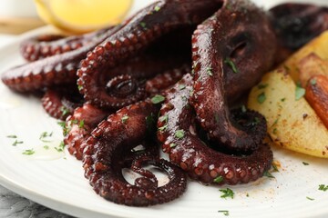 Wall Mural - Roasted octopus with vegetables on table, closeup