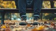 © Larisa - Close-up of legs sitting on a park bench in autumn – concept of solitude, relaxation, self-reflection, for blogs, lifestyle content, seasonal depression awareness, emotional wellness content
