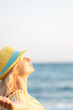 © Sunny studio - Young happy woman enjoying by sunrise against blue sea and sky on summer vacation