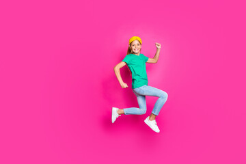 Wall Mural - Full size photo of positive cheerful kid jump run have fun enjoy spring holiday discounts wear blue denim jeans clothes sneakers isolated over pink color background