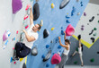 © JackF - Man climbing a tall, indoor, man-made rock climbing wall