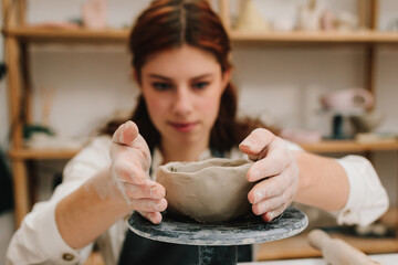 Fototapete - Female potter hands shows ceramic bowl ready for firing in a kiln. The process of creating ceramic products.