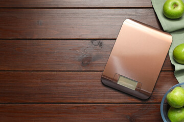 Wall Mural - Electronic kitchen scale and apples on wooden table, flat lay. Space for text