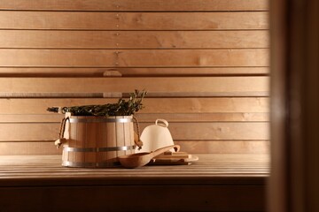 Wall Mural - Bucket, ladle and whisk on wooden bench in sauna. Space for text