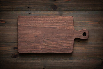 Wall Mural - wooden board on wooden background. handmade walnut wood chopping board on old wooden table.