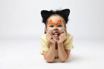 Wall Mural - Cute girl with painted face and ears as cat on grey background