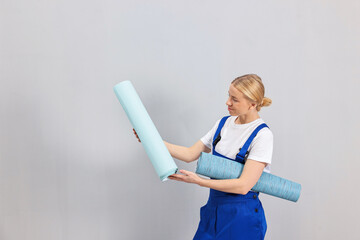 Wall Mural - Female worker with rolls of wallpapers indoors, space for text