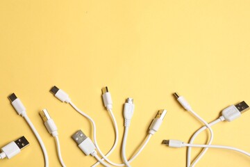 Wall Mural - USB charge cables on yellow background, flat lay. Space for text