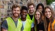 © Anastasiia Havelia - Heroes Without Capes - A group of friends in volunteer vests, smiling in front of a brick wall, embodies the spirit of selfless service. Working for the benefit of people and so