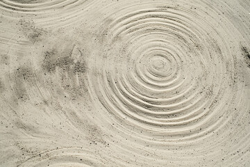 Poster - Concentric circles in sand create textured pattern with subtle shadows