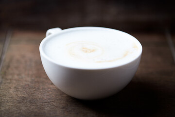 Wall Mural - Cappuccino on dark wooden background. Soft focus. Close up.